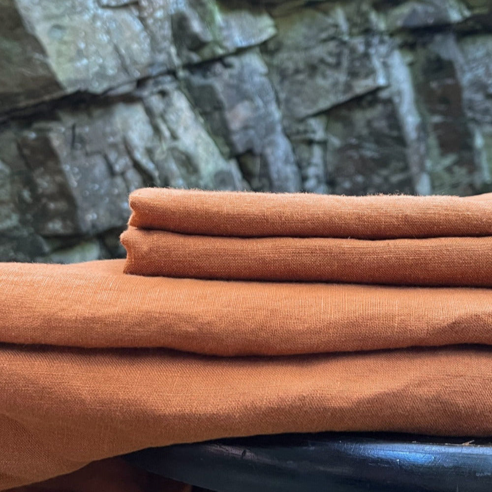 Stack of linen fabric showing a 4 piece sheet set