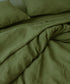 Green bedding set with two pillows on a bed